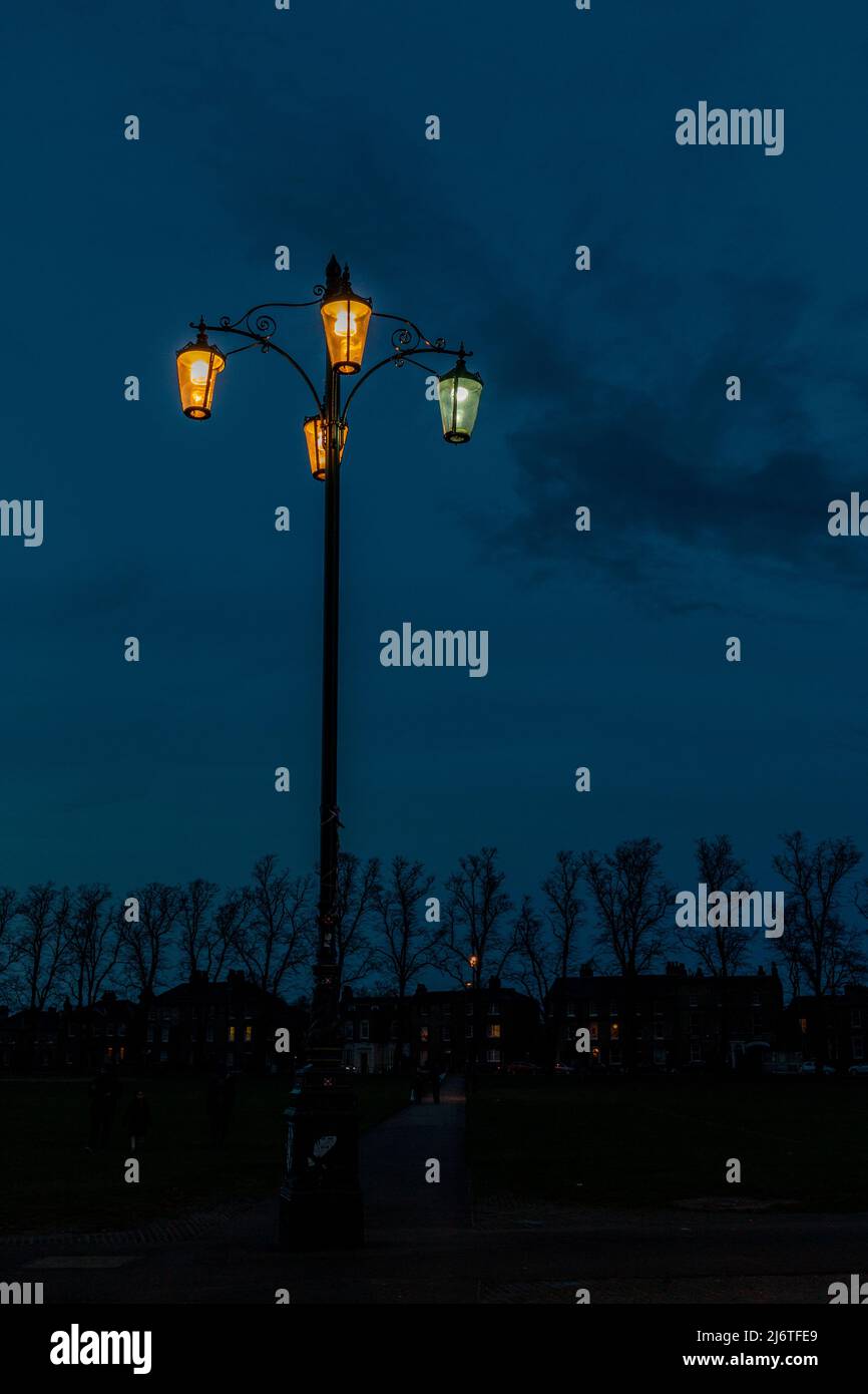 The Reality Checkpoint, a four lantern street light, stands in the darkness in the centre of Parkers Piece, Cambridge, UK Stock Photo