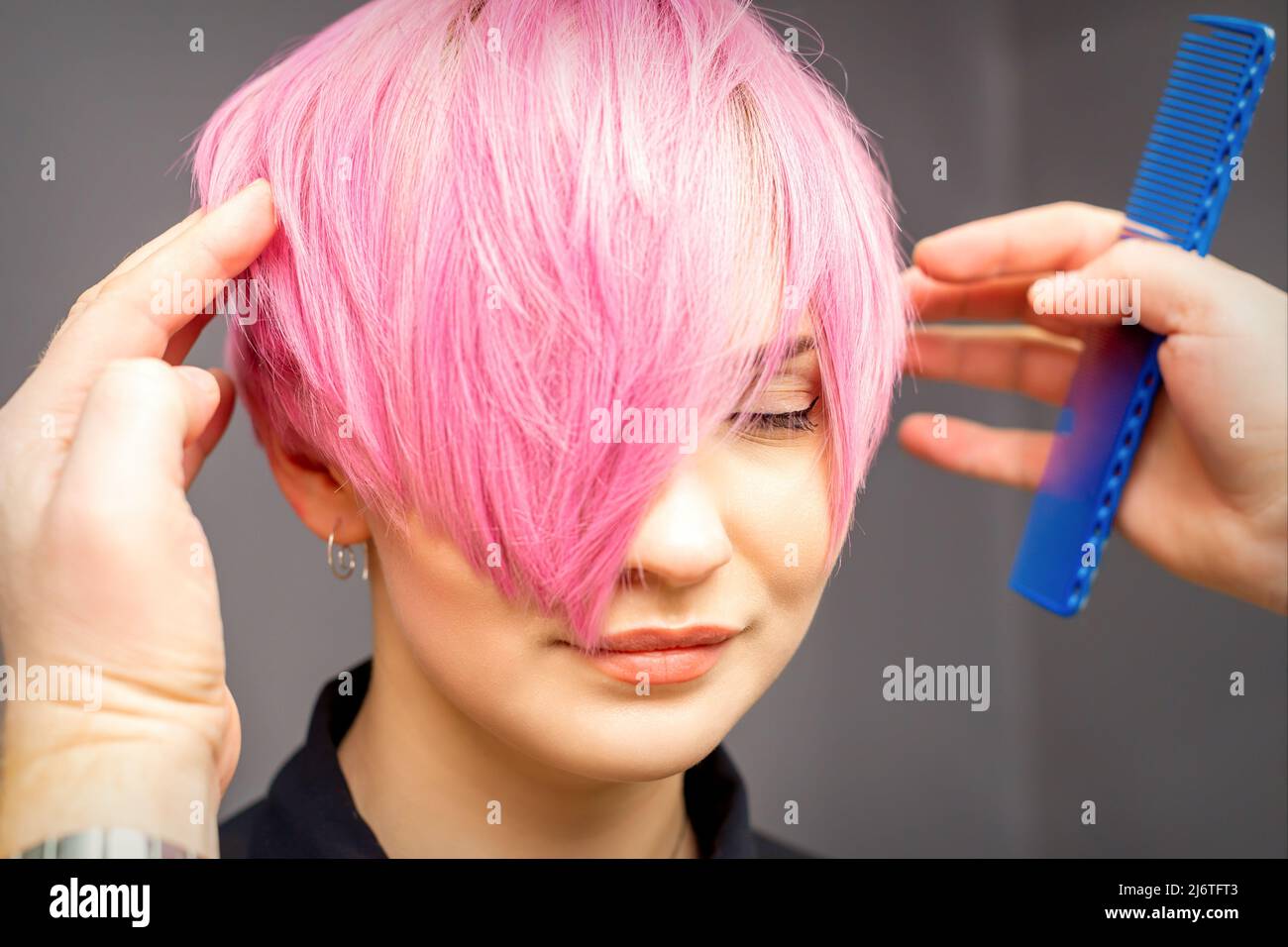 Hairdresser with hands and comb is checking out and fixing the short