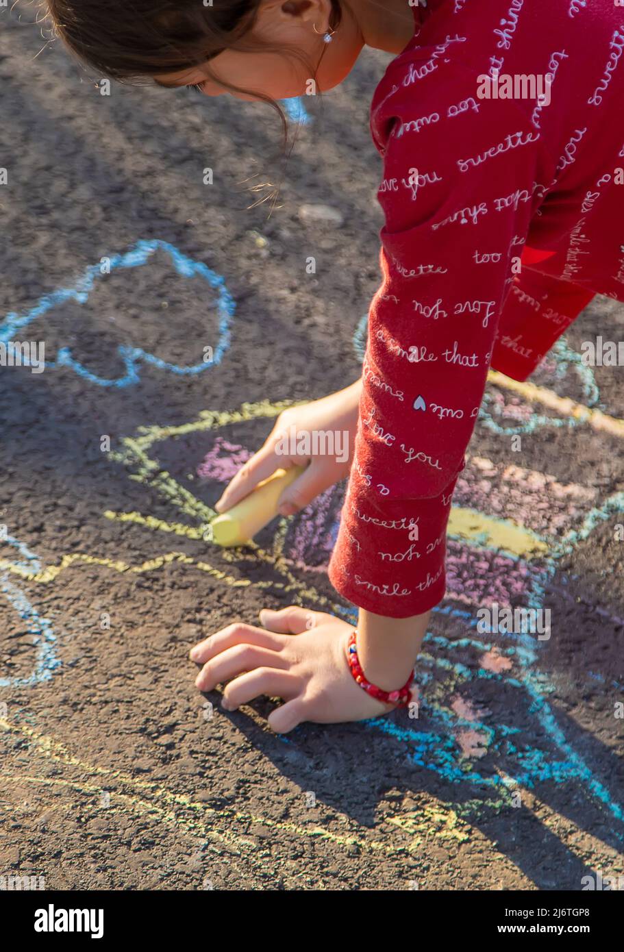 Children draw a house with chalk on the pavement. Selective focus. Kids ...