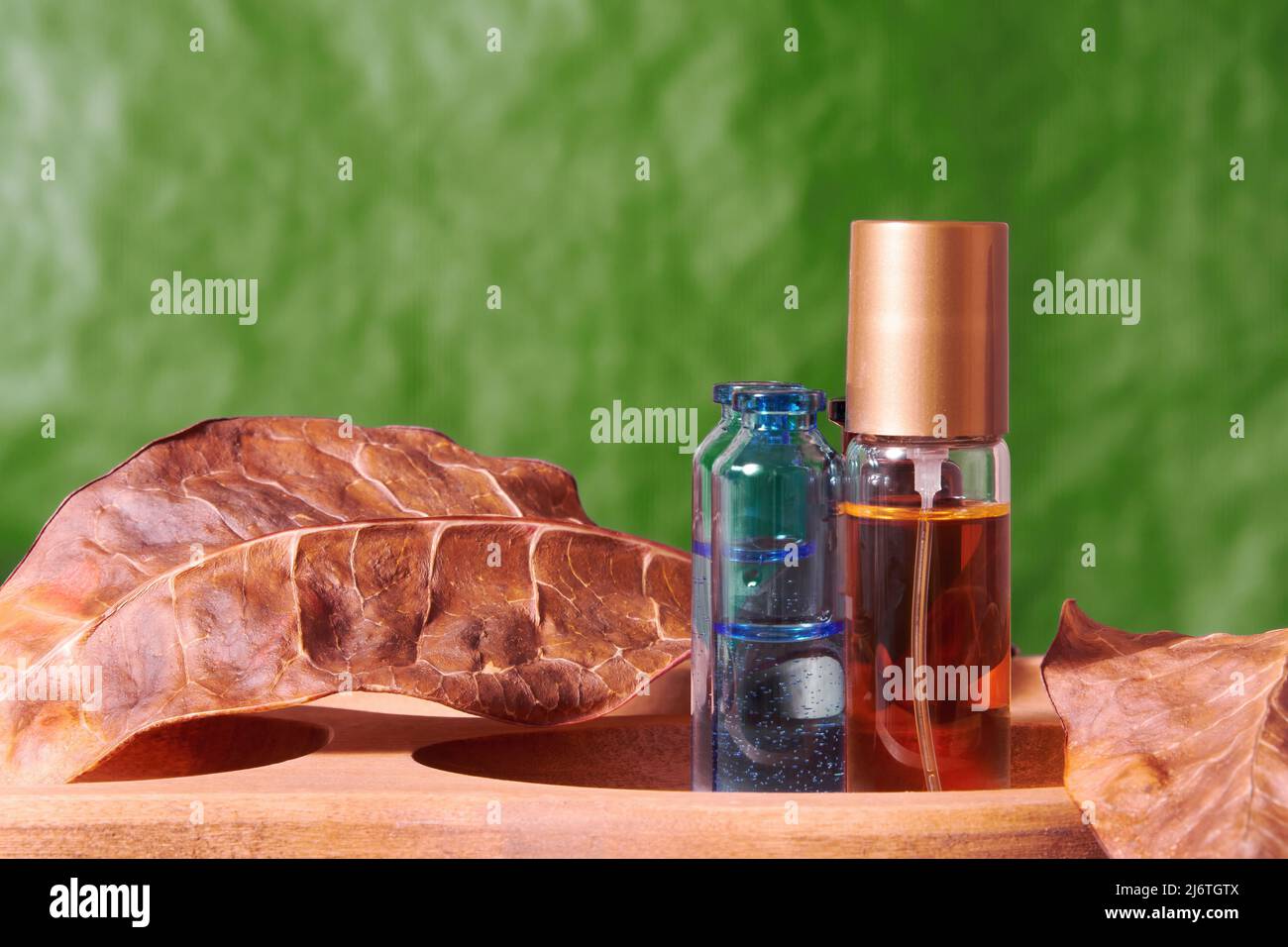 Vivid makeup display with lush perfume vial and jars with tonic. Cosmetics and body care backgrounds Stock Photo
