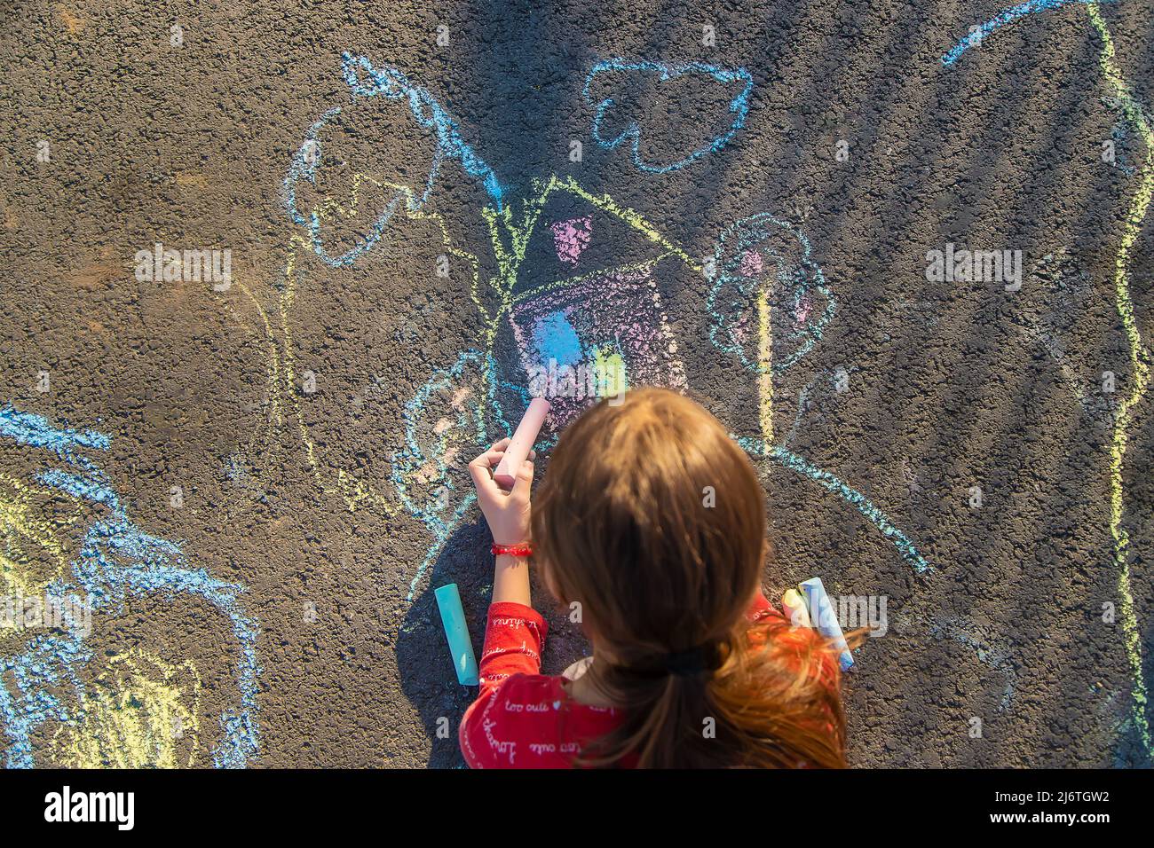 Children draw a house with chalk on the pavement. Selective focus. Kids ...