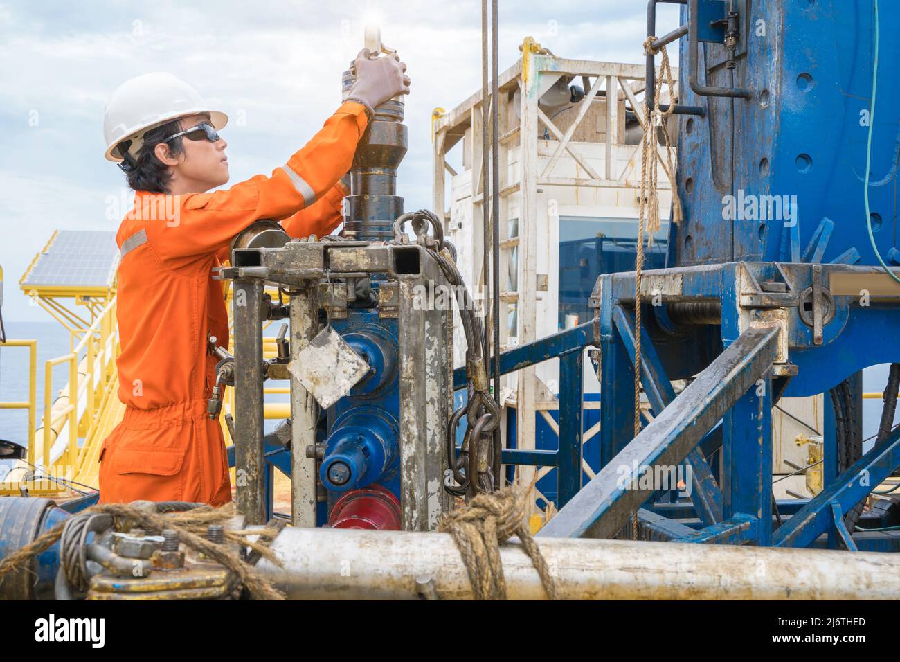 Offshore oil rig worker prepare tool and equipment for perforation oil and gas well at wellhead remote platform. Stock Photo