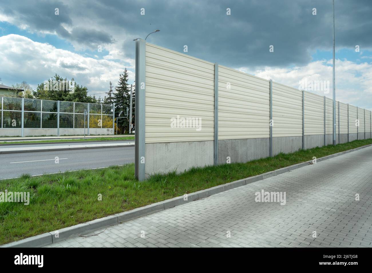 Noise barriers between two roads and cloudy sky Stock Photo