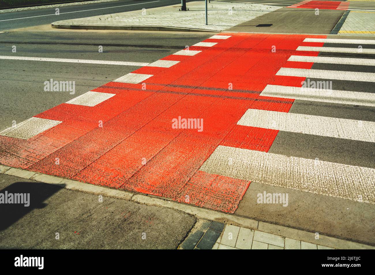 Red bike lane next to pedestrian crossing Stock Photo