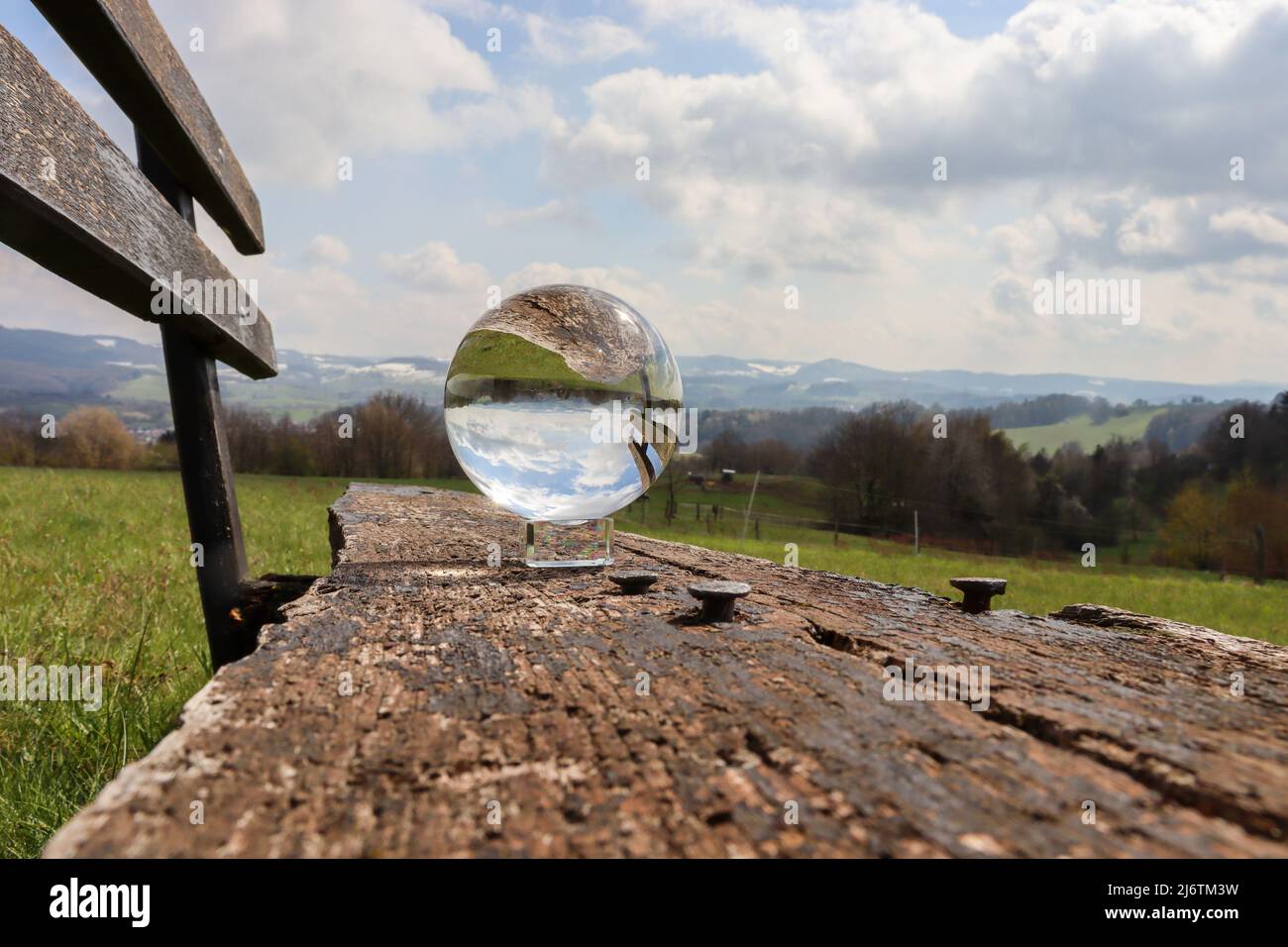 A glass ball with a beautiful reflection in cloudy spring weather on an ...