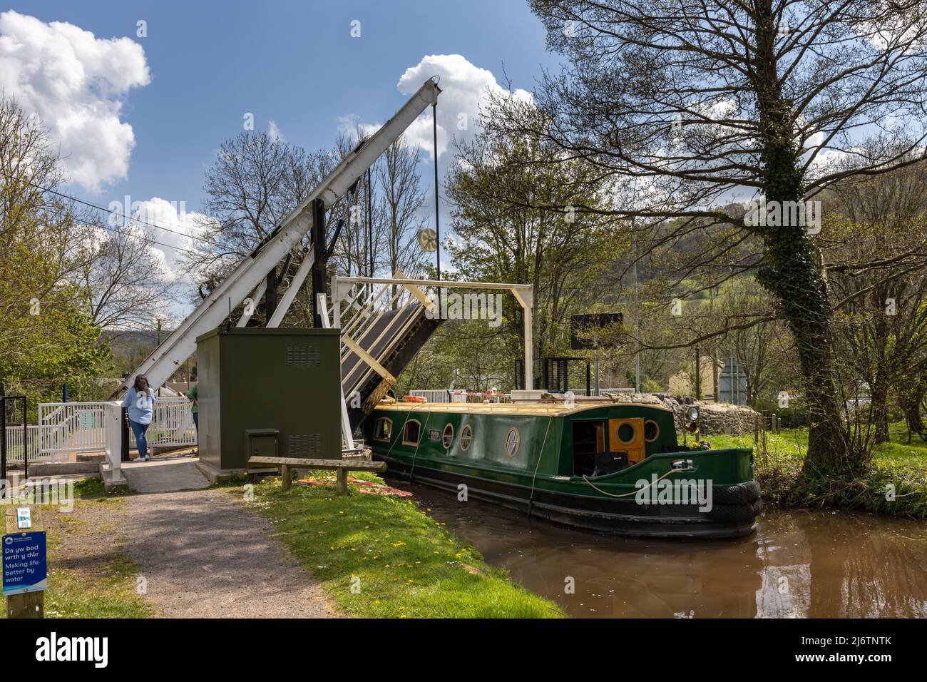 A narrowboat passes through the lift bridge at Talybont-on-Usk on the Monmouthshire and Brecon Canal, Brecon Beacons National Park, Powys, South Wales Stock Photo