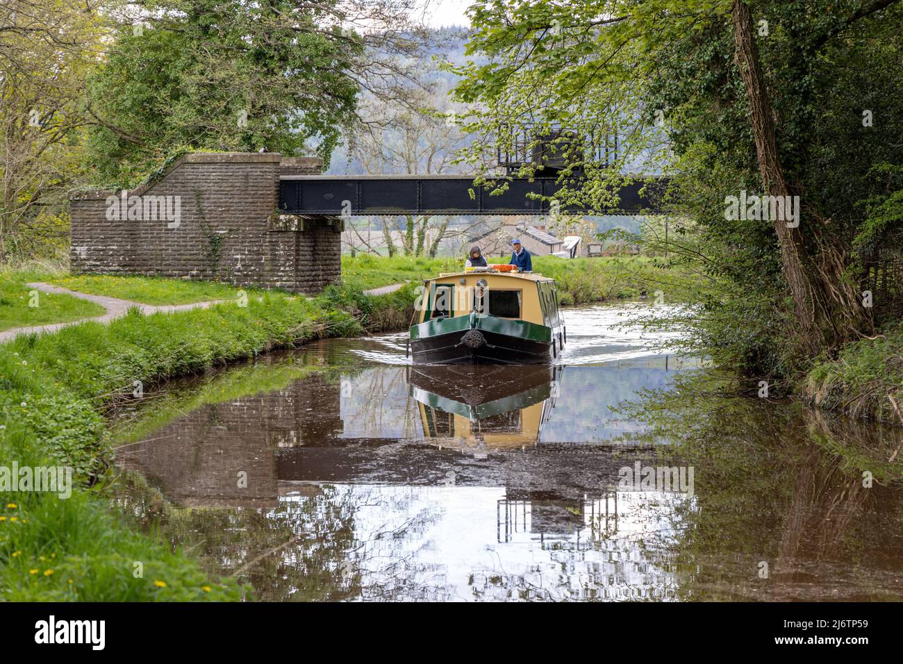 Narrowboat holiday makers navigate the Monmounthshire and Brecon Canal near Talybont-on-Usk in the Brecon Beacons, Powys, South Wales, UK Stock Photo
