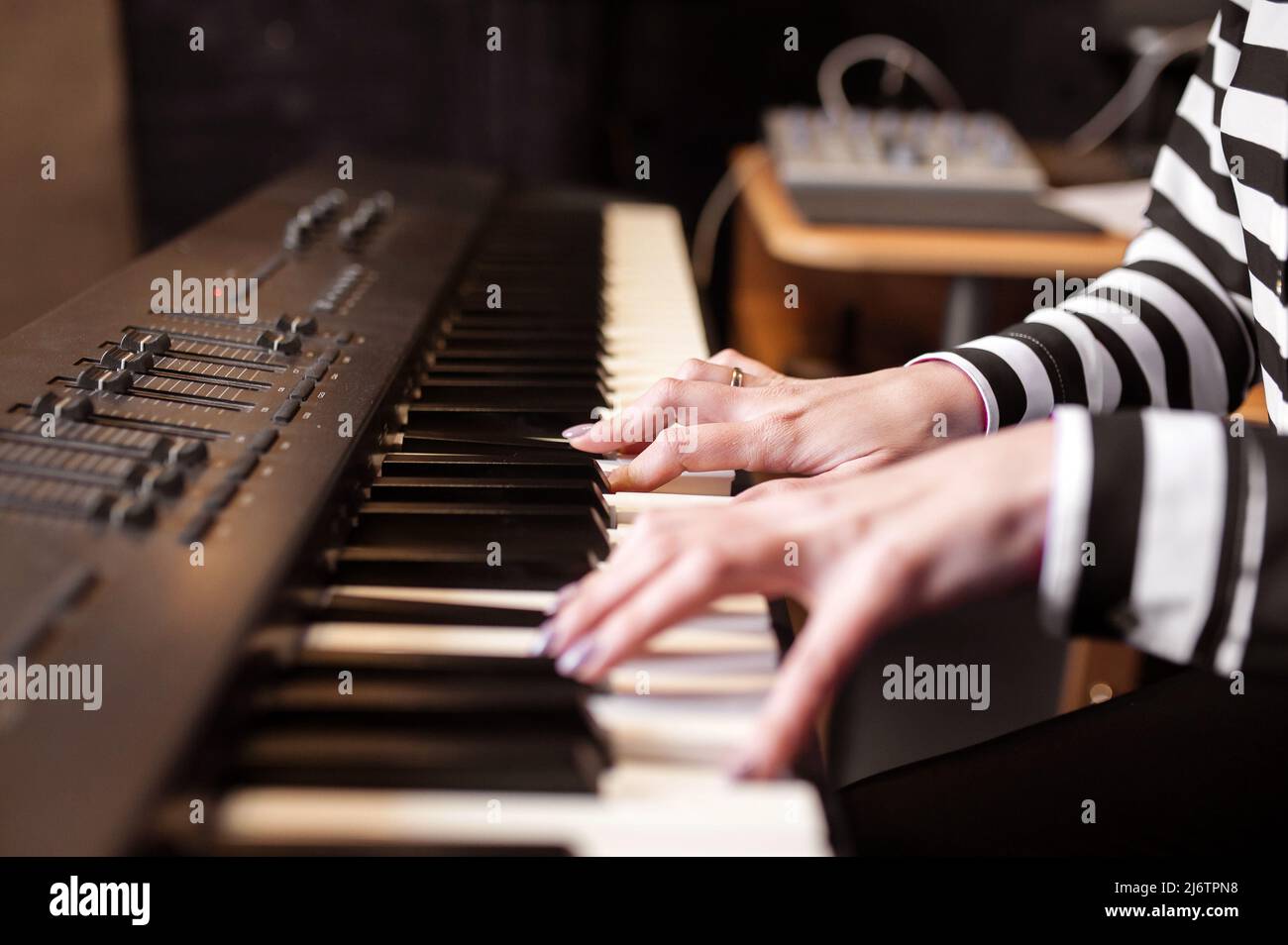 Woman playing piano record music on synthesizer using notes and laptop.  Female hands musician pianist improves skills playing piano. Online Music  educ Stock Photo - Alamy