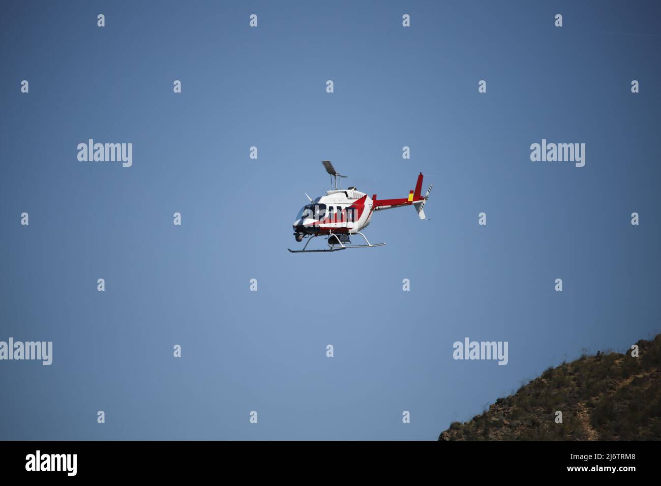 An helicopter EC-EUT checks the river in the mountains Stock Photo