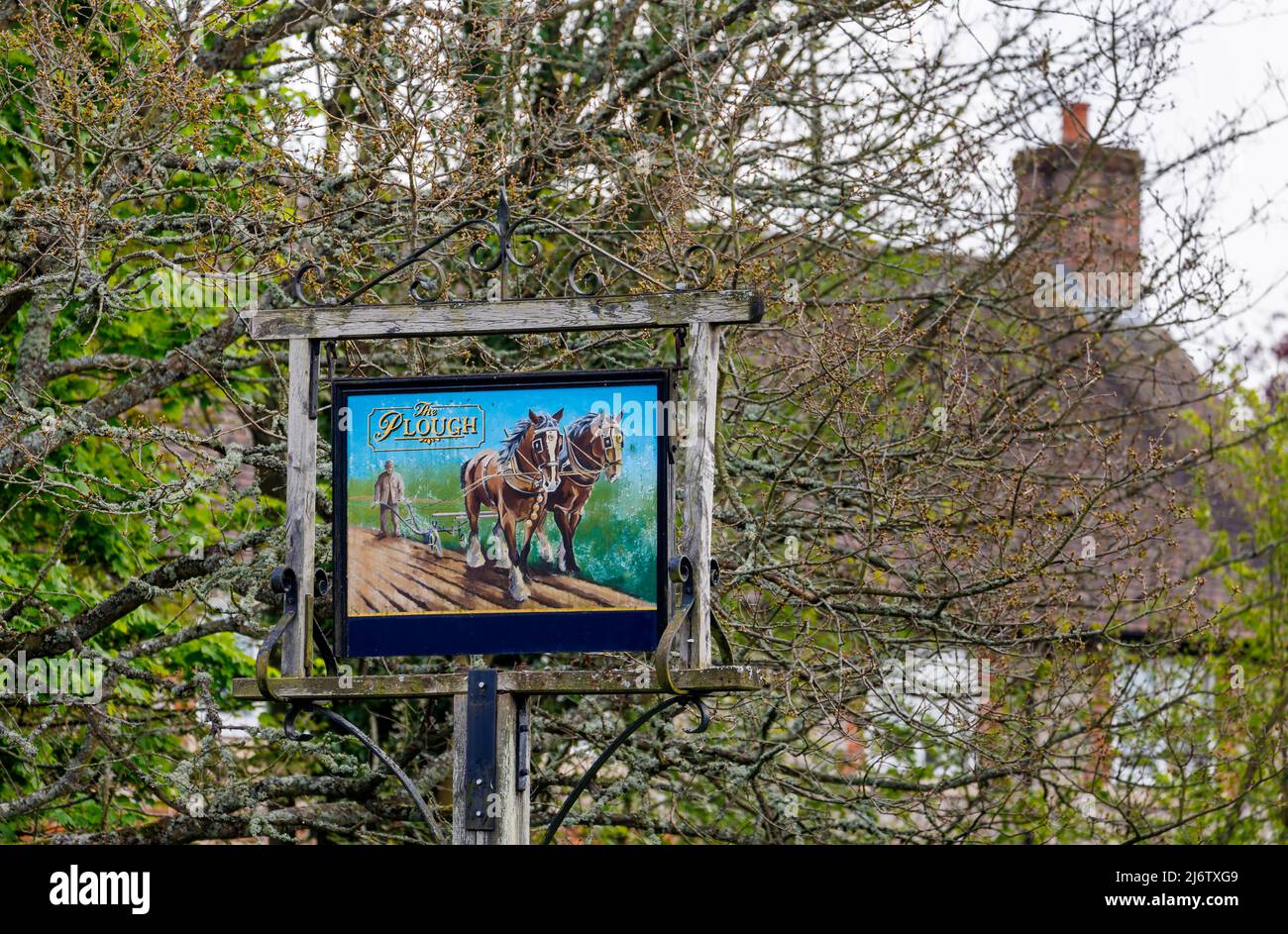 Traditional pole-mounted painted pub sign outside The Plough, a pub Shalbourne, a small unspoilt village in rural Wiltshire, England Stock Photo