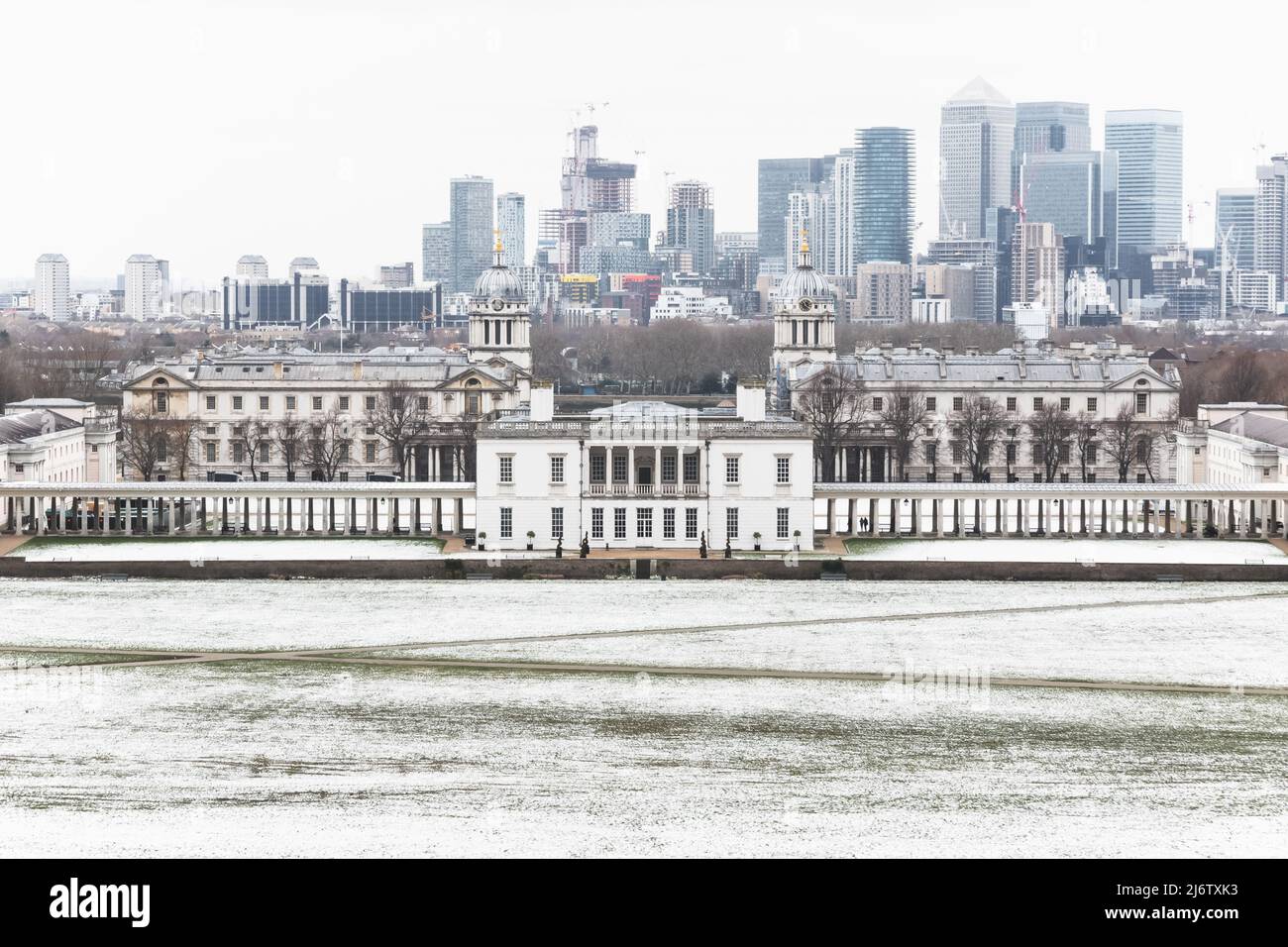 View of Queens House and Canary Wharf from Greenwich Park, London in winter snow Stock Photo