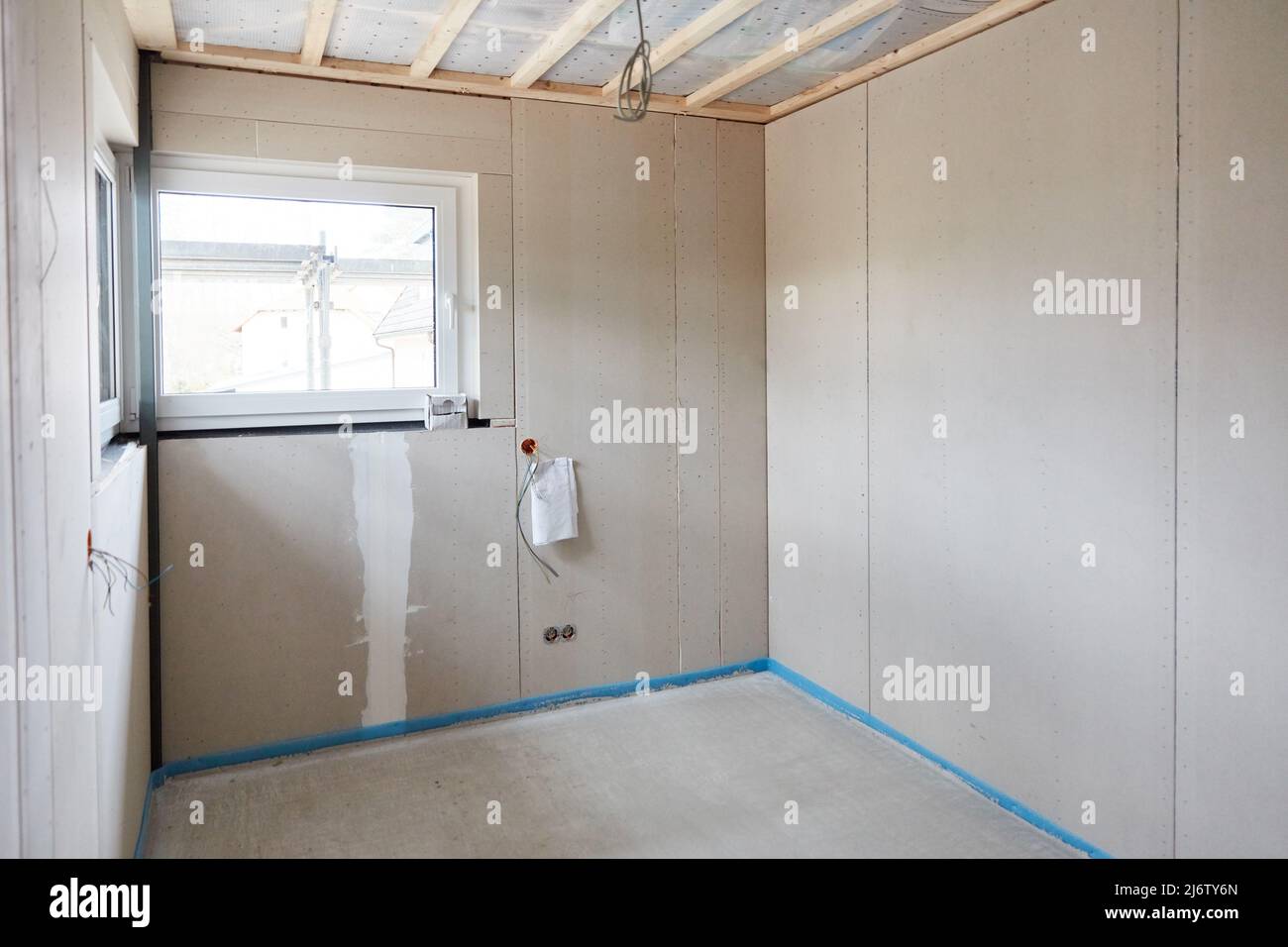 Fresh screed laid in house construction in room with corner window in interior design Stock Photo
