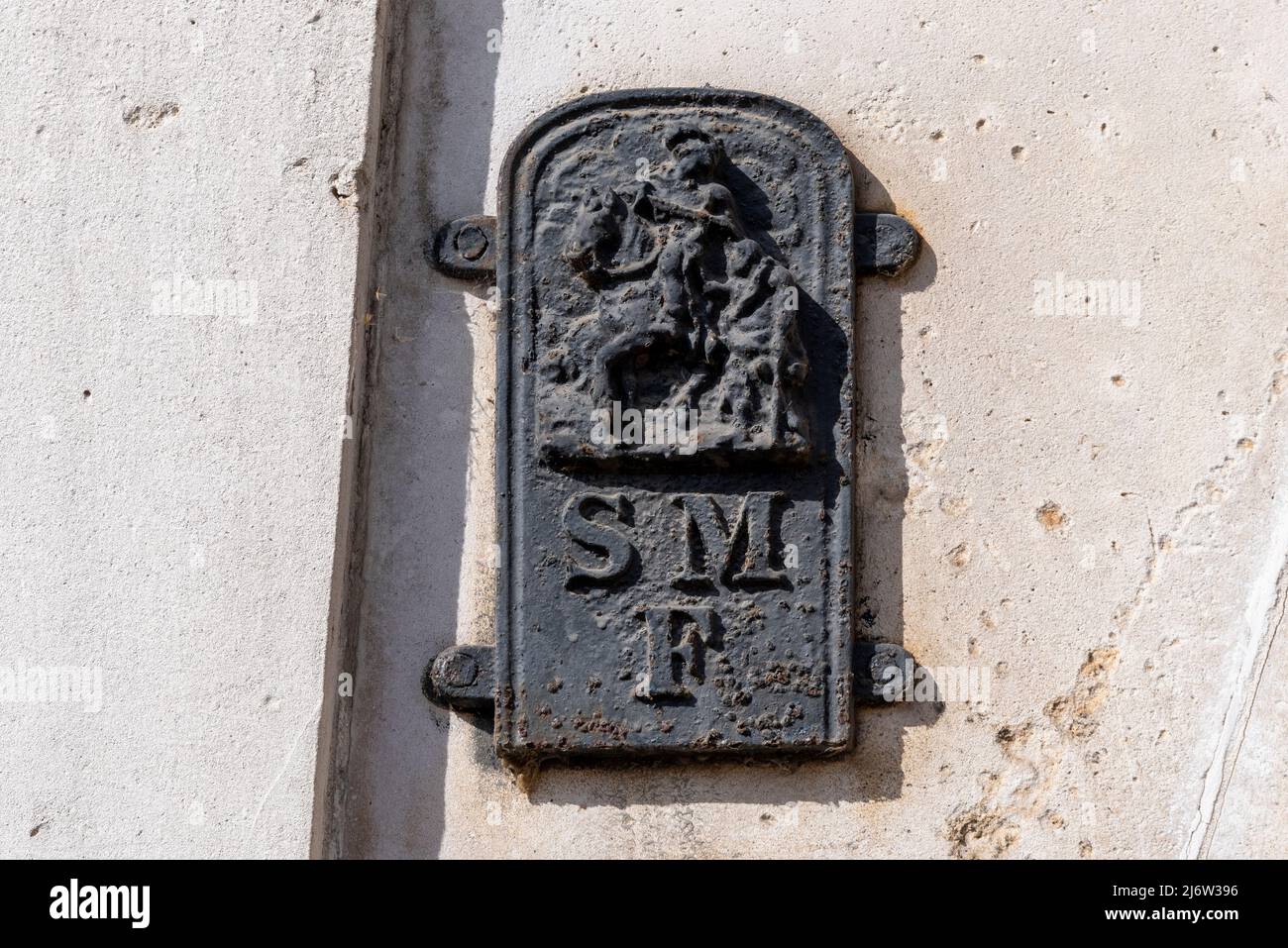 Old metal plate, plaque, on Horse Guards building with a soldier on horseback and the letters SMF. Denotes the boundary of St Martin-in-the-Fields Stock Photo