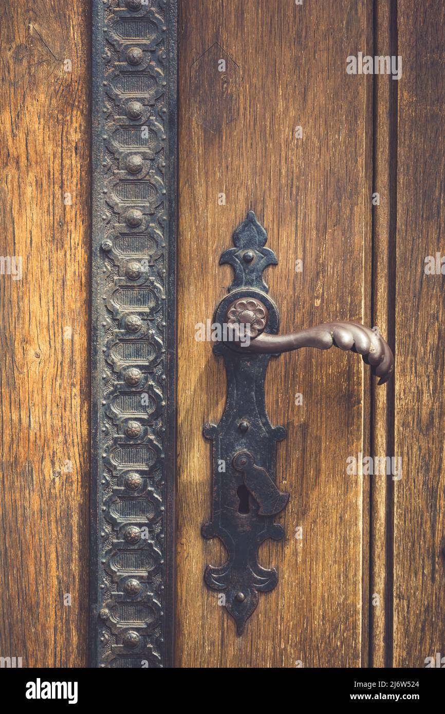 Vintage antique door handle on the old wooden door. Copper keyhole