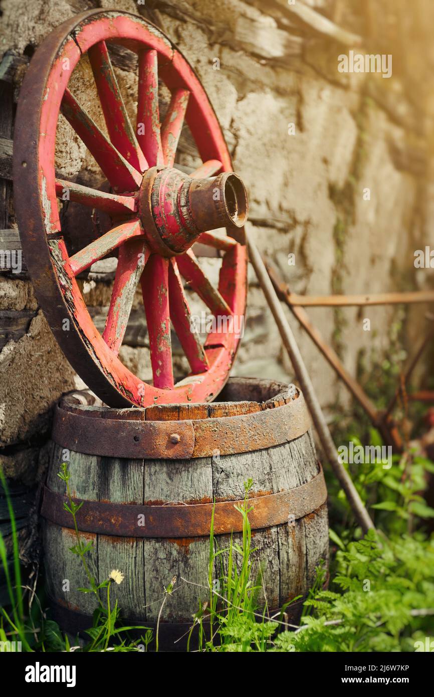 Old vintage hearse wheel and wooden barrel, rural scene Stock Photo