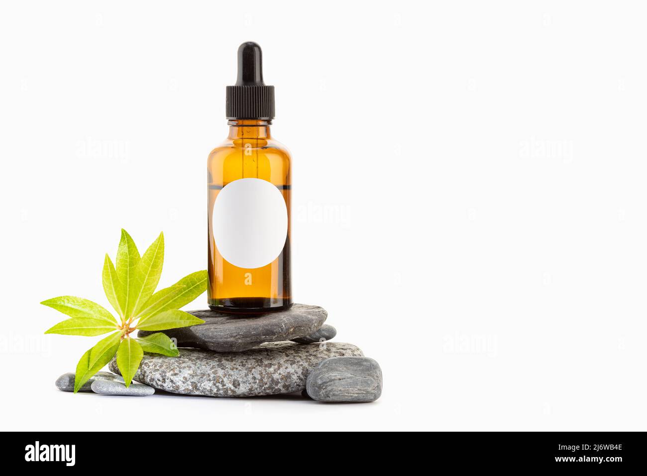 Herbal Essential oil on amber bottle with blank label isolated on white background. Template Mock up. Copy space Stock Photo
