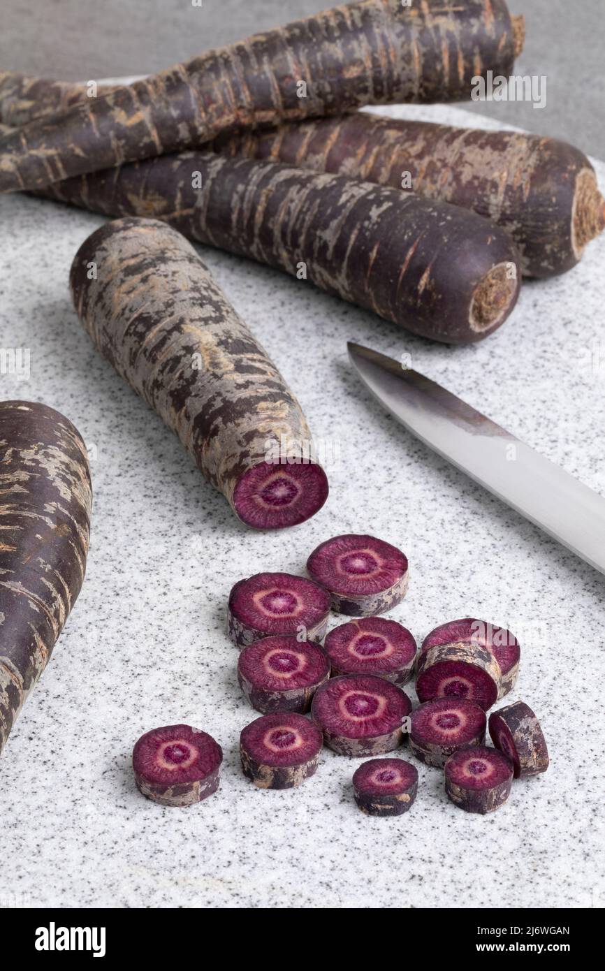 Purple carrot and slices on a cutting board close up Stock Photo
