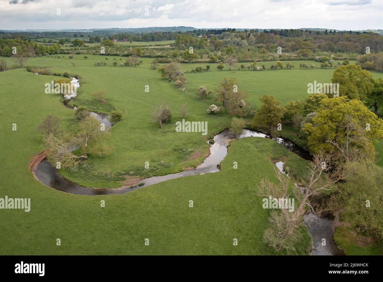 Aerial view of the twisting river Arrow running through farm land in Warwickshire, England. Stock Photo