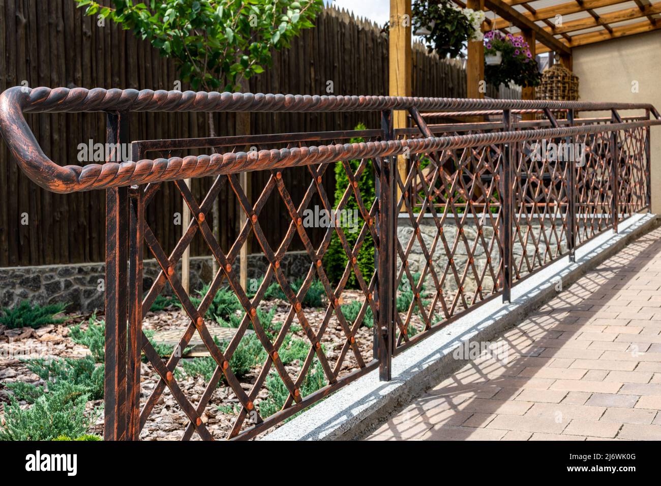 Forged metal products. Antique styling. Iron fence with mesh Stock Photo