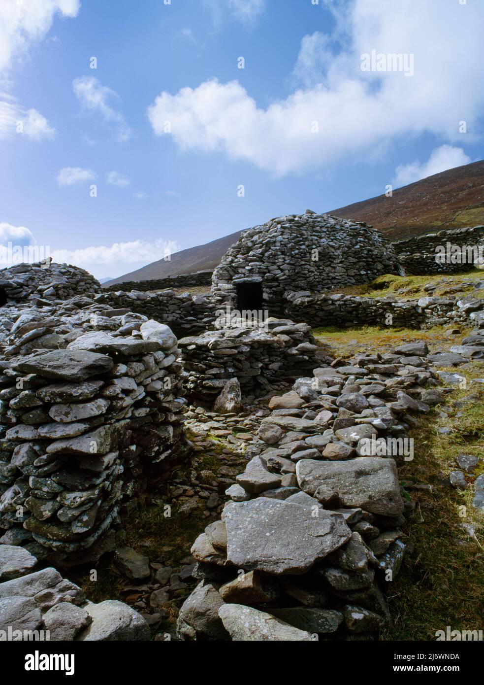 View NW of beehive huts (clochans) within the circular stone wall of Caher Martin cashel (fort), Glanfahan, Dingle, County Kerry, Republic of Ireland. Stock Photo