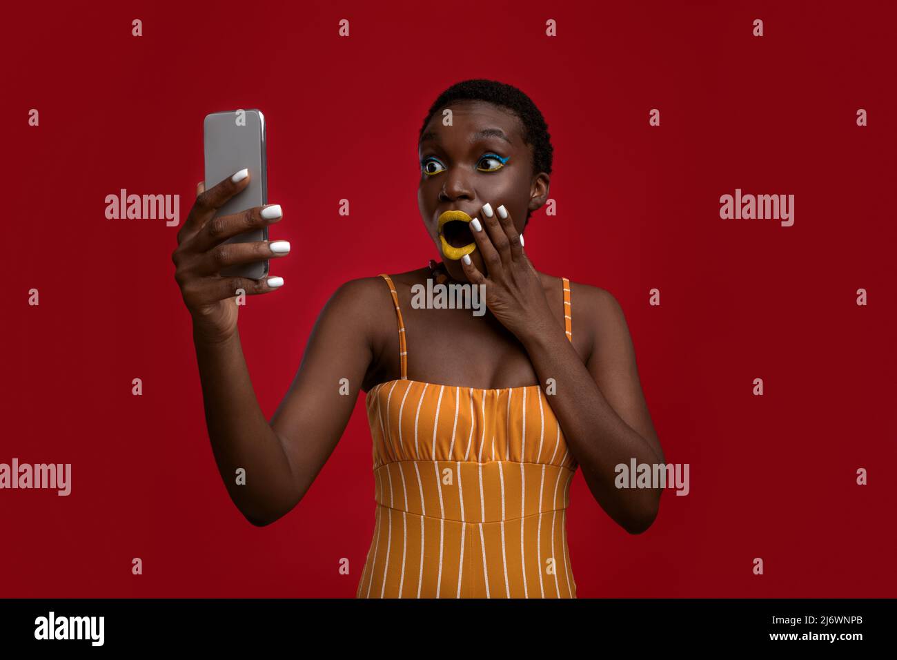 Emotional black lady holding modern cell phone Stock Photo
