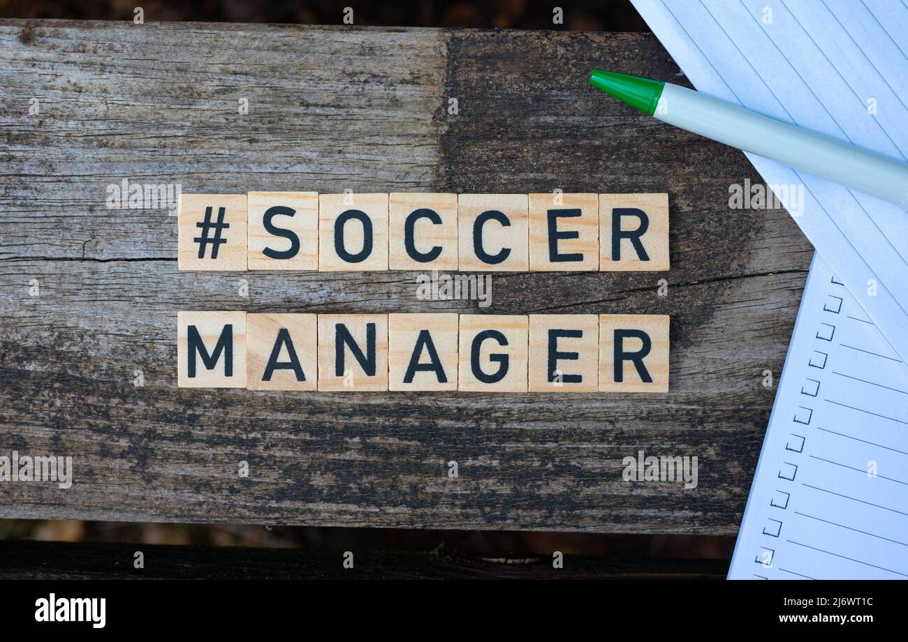 Wooden toy blocks with the text Soccer Manager on it with pen and paper in the background. Perfect shot for football managers, managers, bloggers. Stock Photo