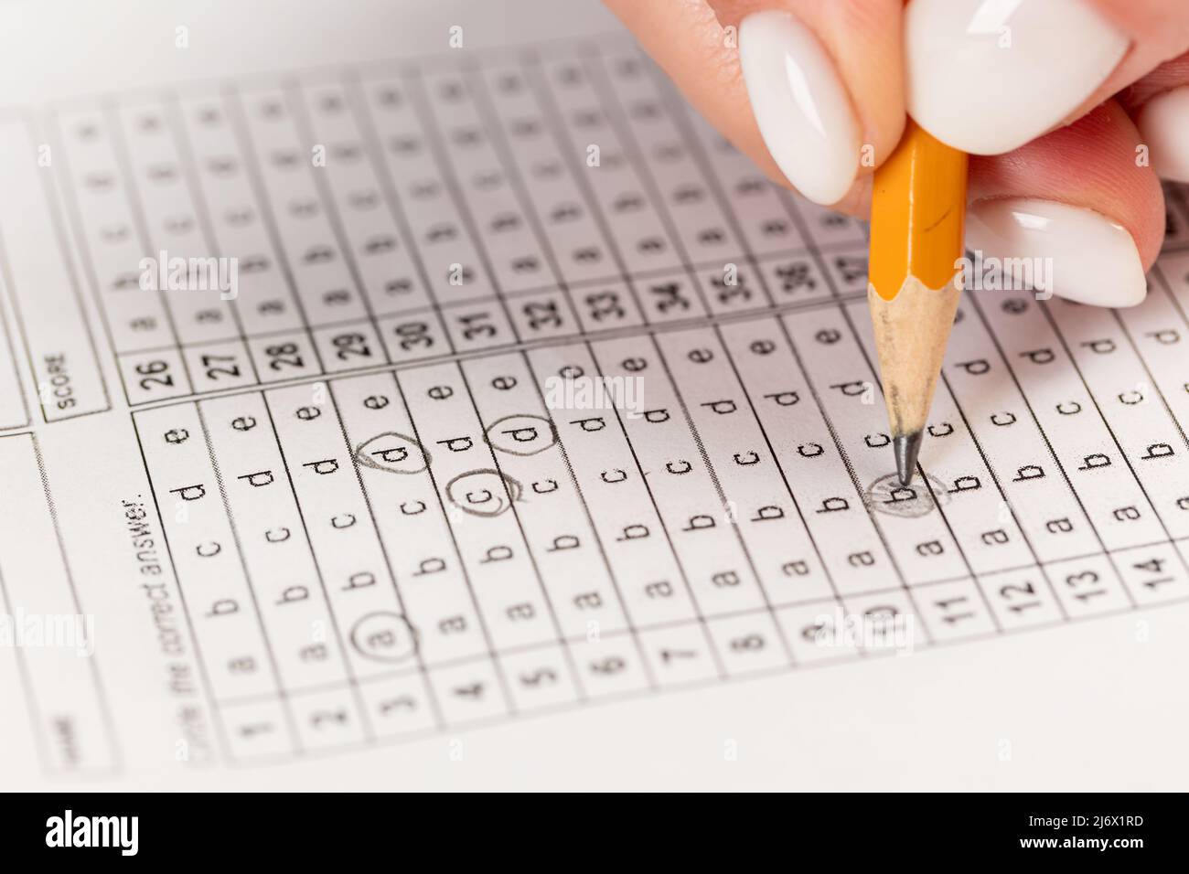 Female hand holds pencil and marks answers to test. Hiring Testing