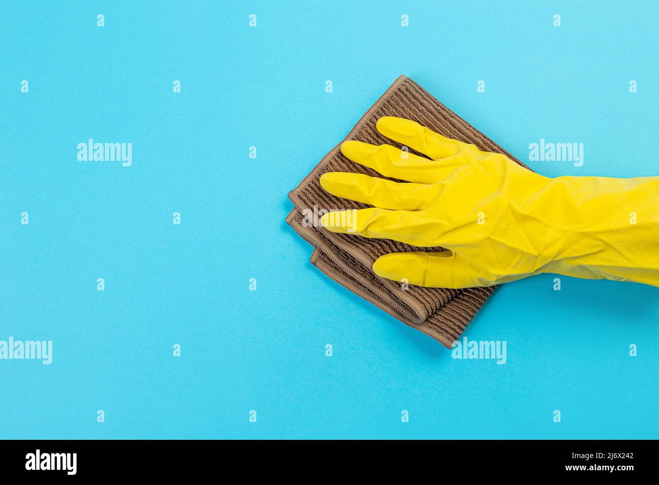 worker hand in a yellow rubber protective glove with a micro fiber ...