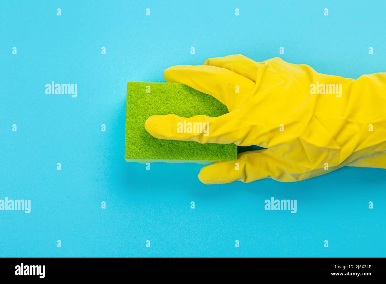 worker's hand in yellow rubber protective glove with micro fiber green ...