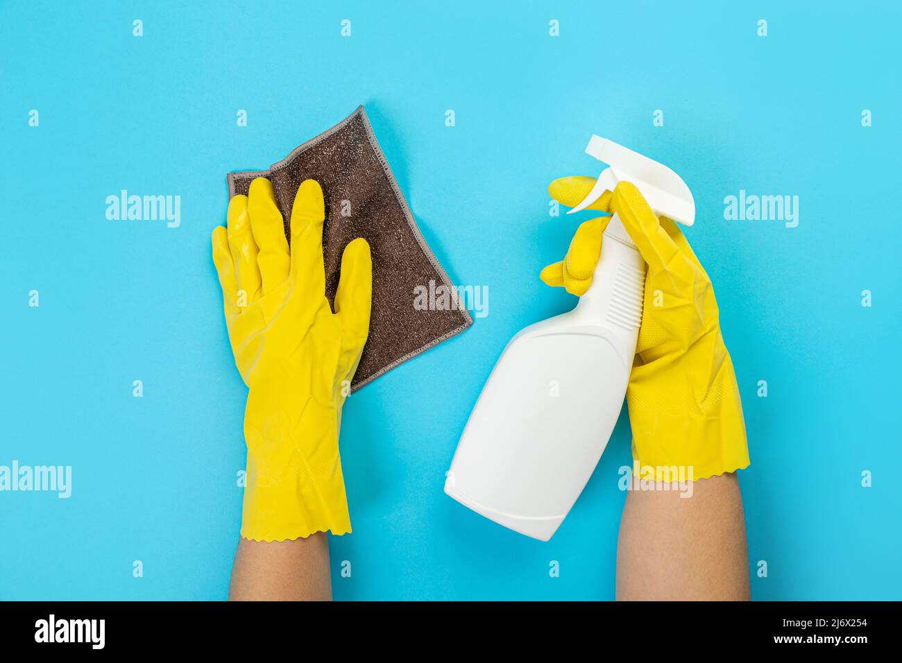 The hands of a housewife in yellow rubber protective gloves hold a ...