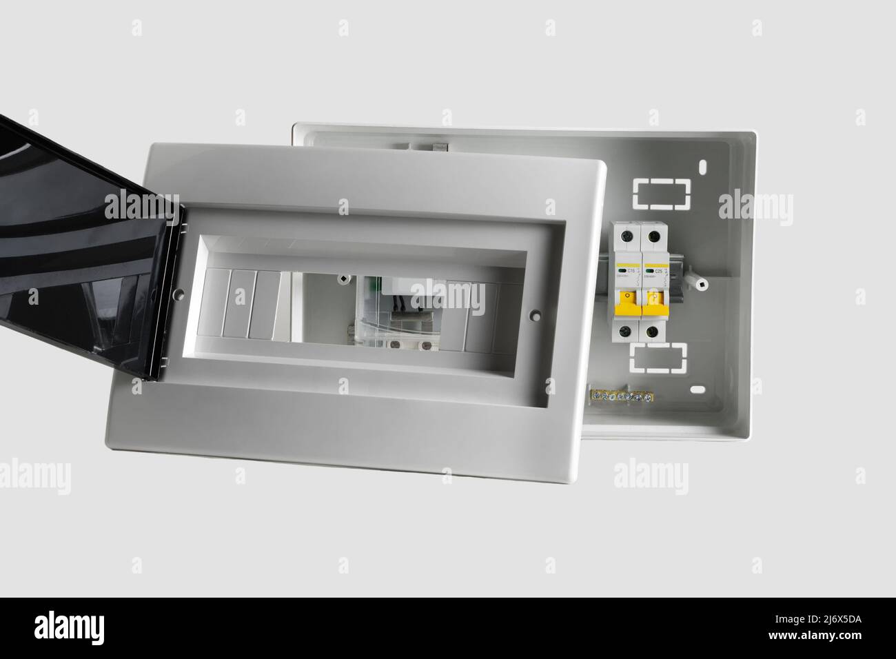 Plastic distribution board. Electrical board. Close-up. Isolated on light gray background. Stock Photo