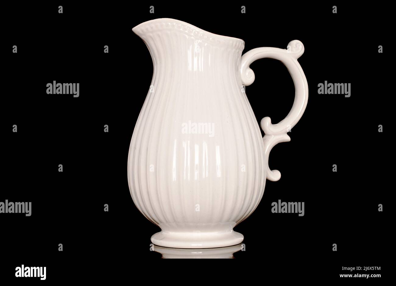 https://c8.alamy.com/comp/2J6X5TM/one-ceramic-milk-jug-close-up-isolated-on-a-black-background-2J6X5TM.jpg