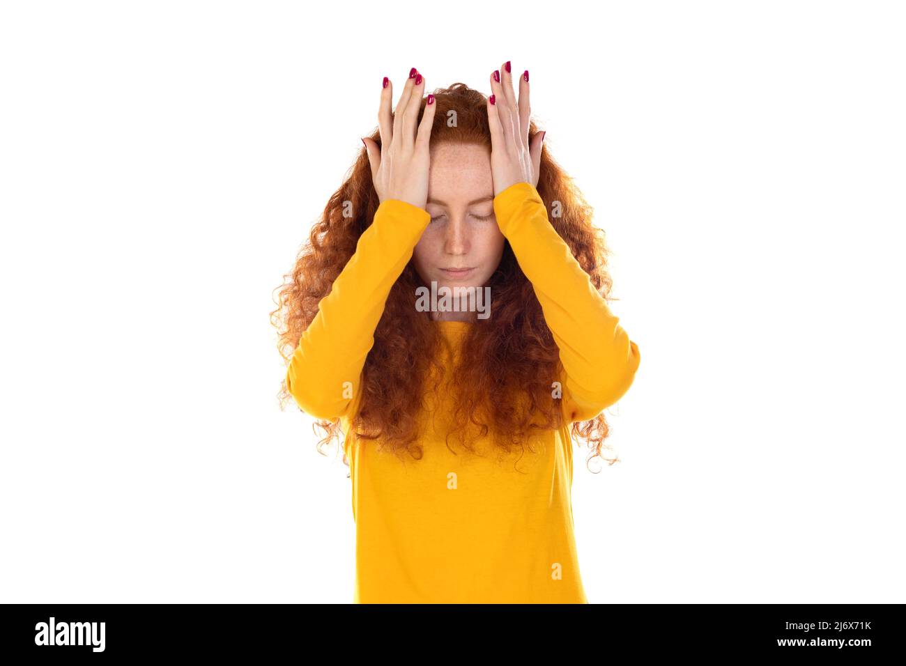 Beautiful fragile redheaded young woman in the dark. Sad frightened girl scared of abuse. Nonverbal behavior, body language. Red hair female looking s Stock Photo