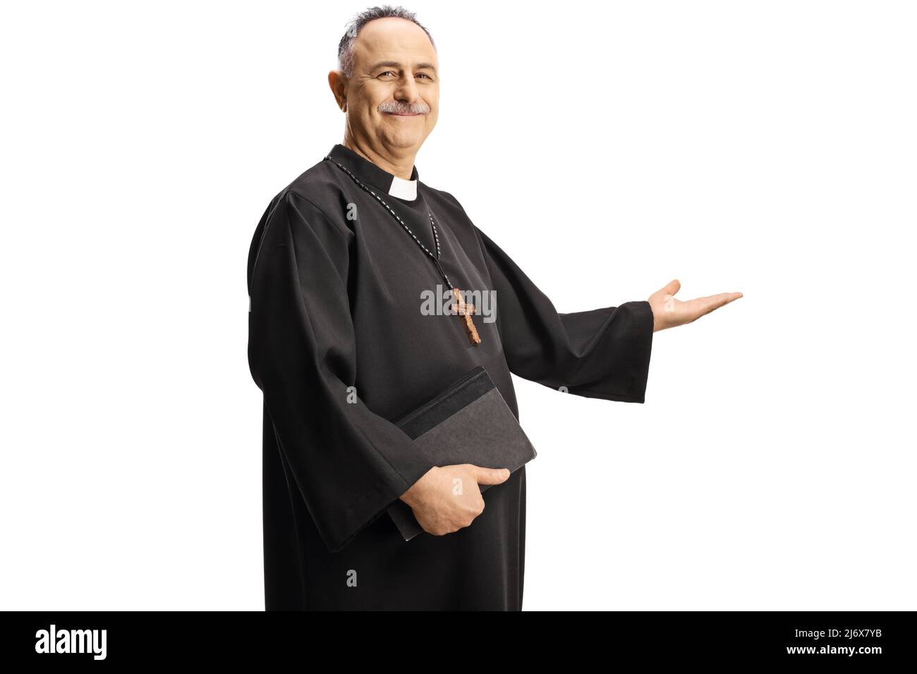 Mature priest gesturing welcome and holding a bible isolated on white background Stock Photo
