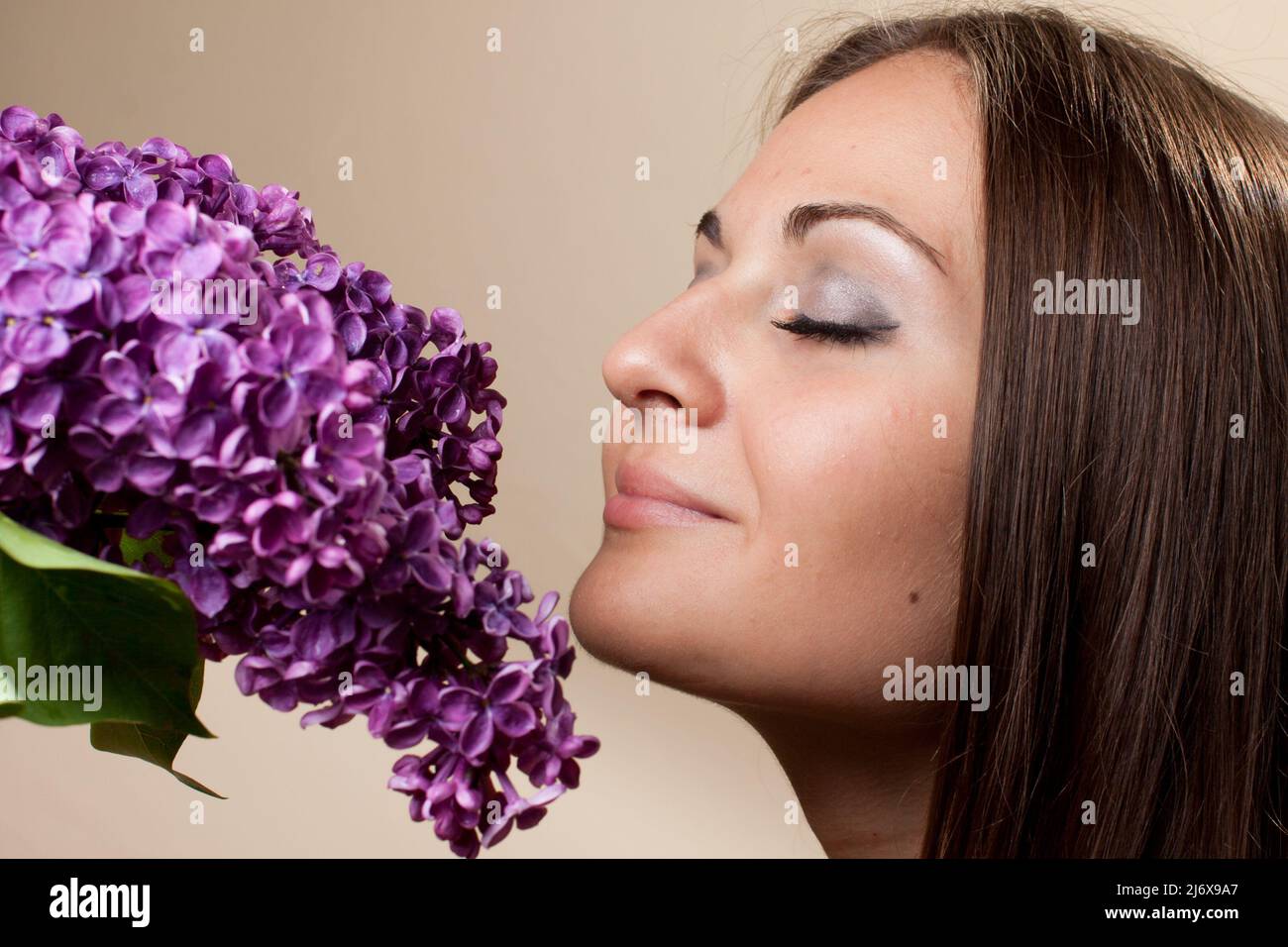 Beautiful young girl weared in black dress with a bouquet of lilac ...