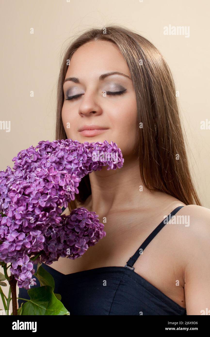 Beautiful young girl weared in black dress with a bouquet of lilac ...