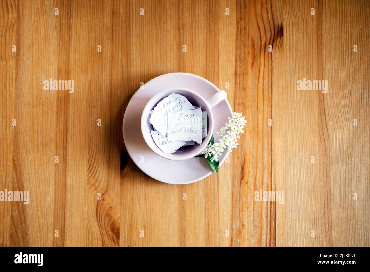 Affirmation, inspirational quotes concept. Paper with motivation message and inspirational quotes in pink tea cap on wooden table Stock Photo