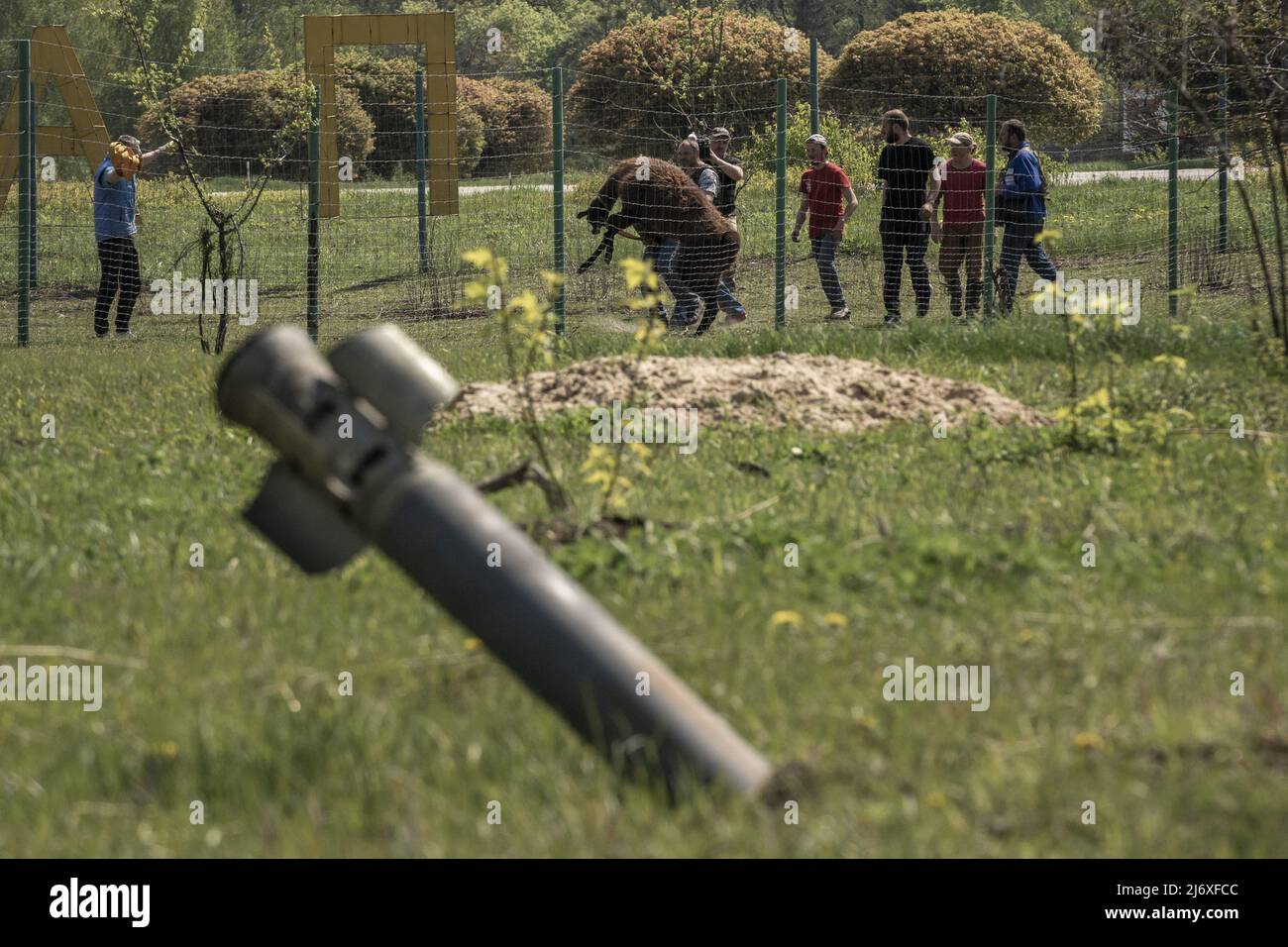 An unexploded ordnance sticks out of the ground as Eco-Park employees chase after a llama to be rescued and brought to the town Poltava for safety after Russians shelled the area, killing dozens of animals outside of Kharkiv, Ukraine on Monday, May 2, 2022. Russia fired incendiary rockets into Ukraine's second-largest city on Wednesday -- which ignited a large fire in a civilian neighborhood of Kharkiv -- after ramping up missile attacks across the battle-scarred country.     Photo by Ken Cedeno/UPI Stock Photo