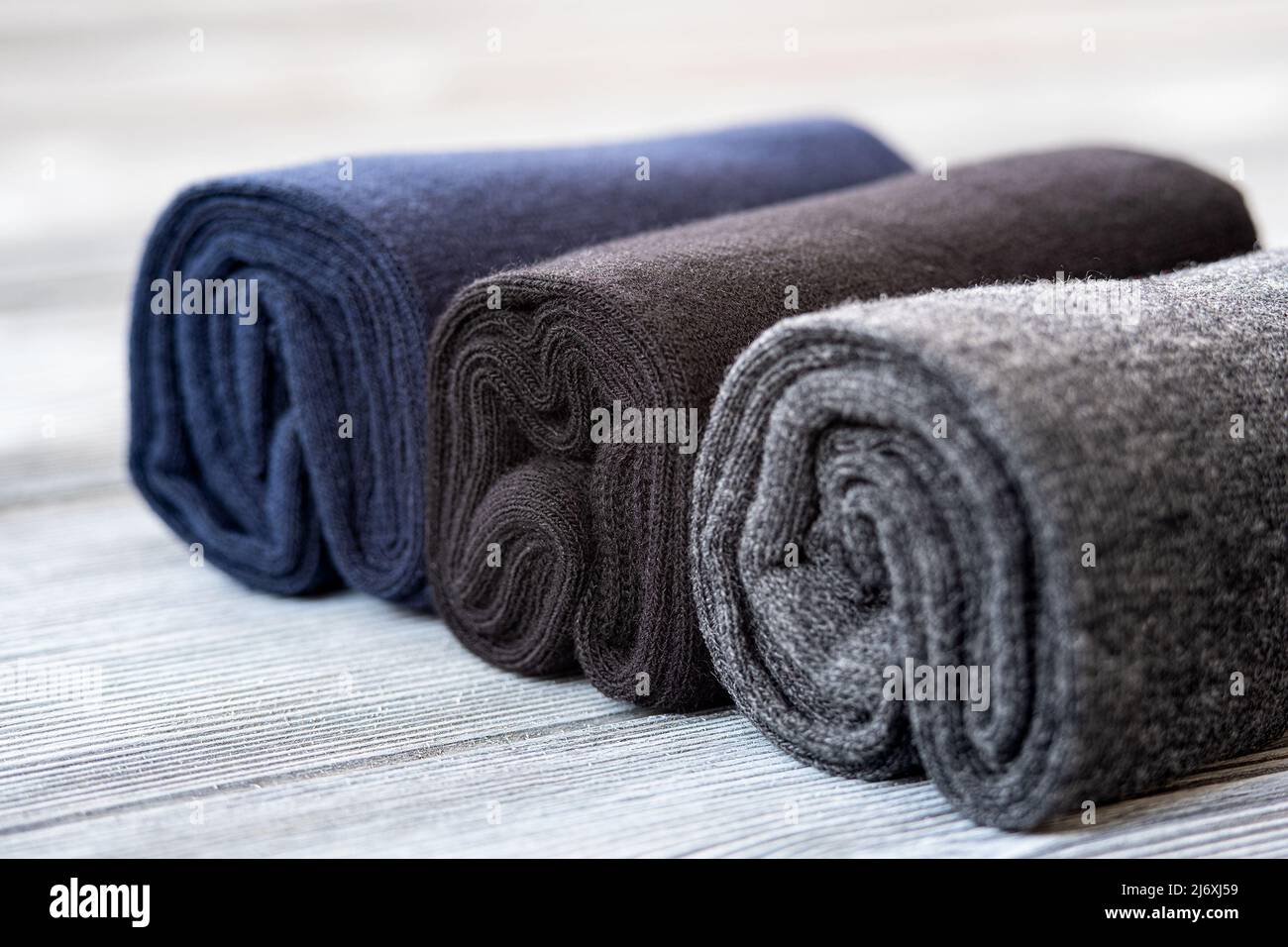 A set of gray, blue and black socks, rolled up for storage Stock Photo