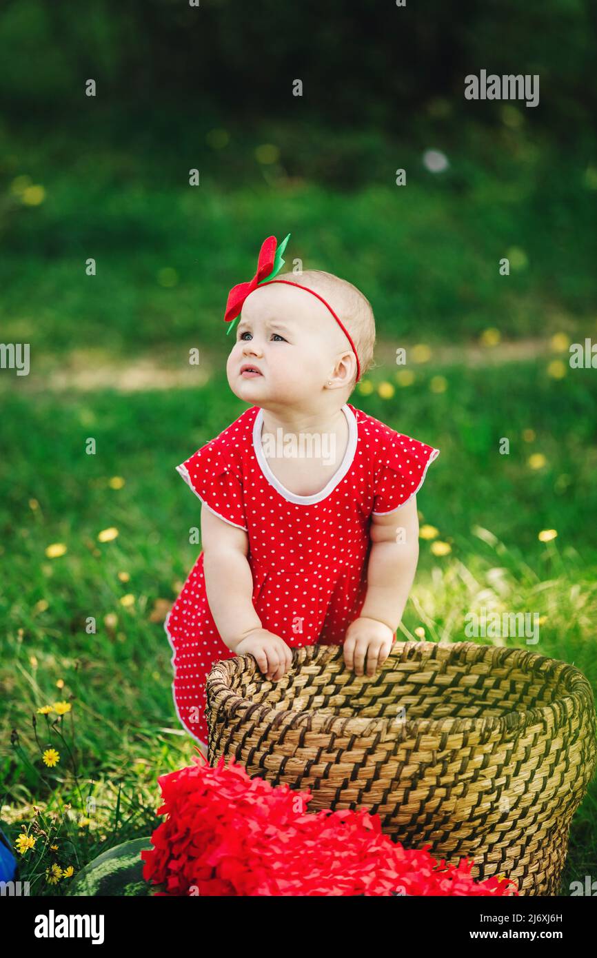 Cute 10 months baby girl on picnic on grass with watermelons. child in red dress and bow on head. Concept of healthy eating childhood fruit ripeness Stock Photo Alamy