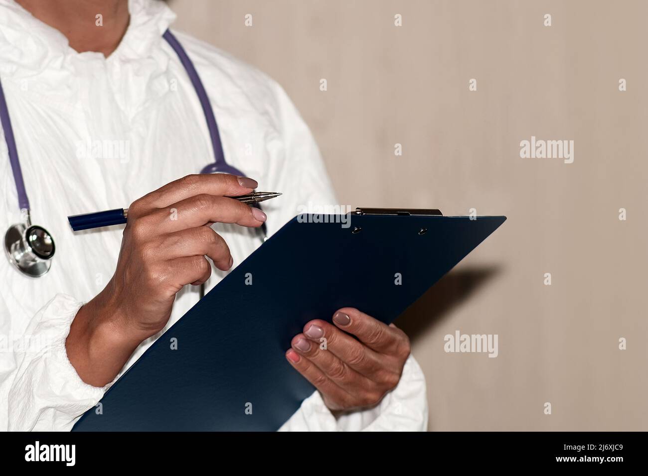 Close-up of a doctor holding a tablet with a questionnaire. The stethoscope is prepared for examination of the patient Stock Photo