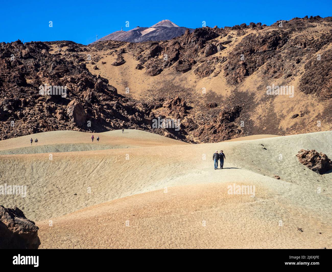 A heterosexual couple strolling through the volcanic landscape of the Teide volcano on the island of Tenerife Stock Photo