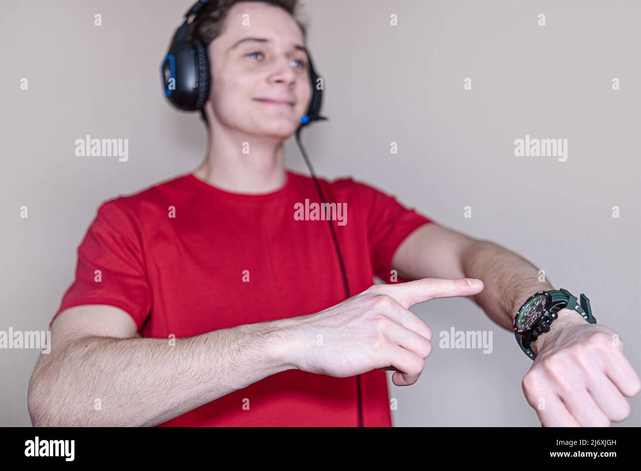 Background, blur, out of focus, bokeh. A young guy points his finger at the dial. The Concept Of Headphones For Listening To Music By A Person Stock Photo