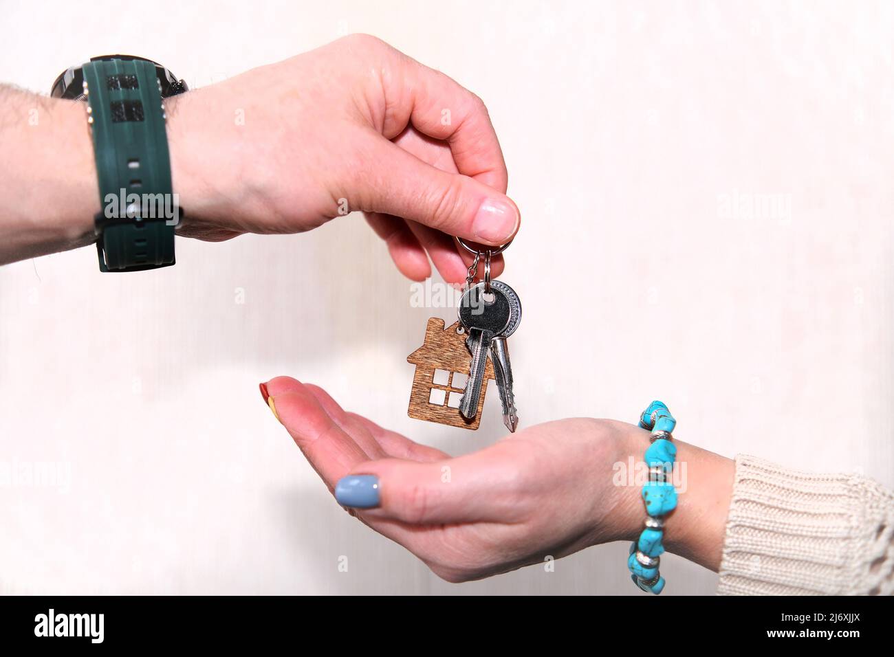 A bunch of keys with a keychain in your hand. Close-up view of the realtor-landlord's hand handing the key to the house to the buyer-tenant Stock Photo