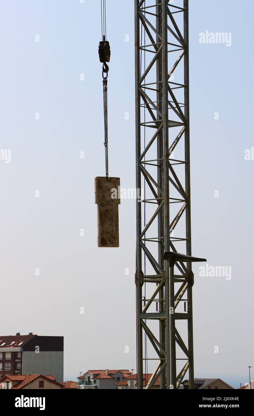 Mobile crane lifting a concrete counterweight into position for a tower