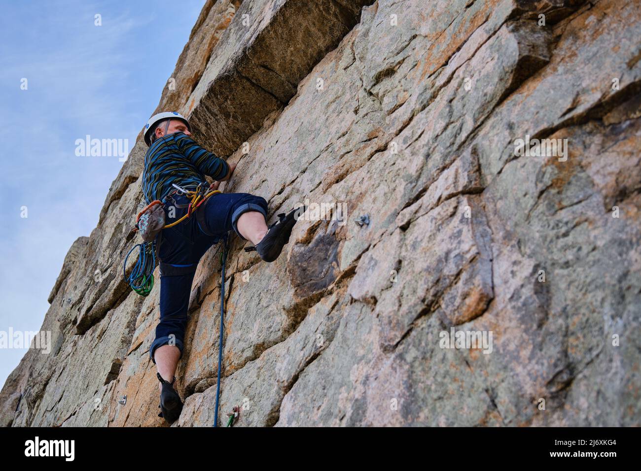 Concentrated adult male climbing a rock wall Stock Photo - Alamy