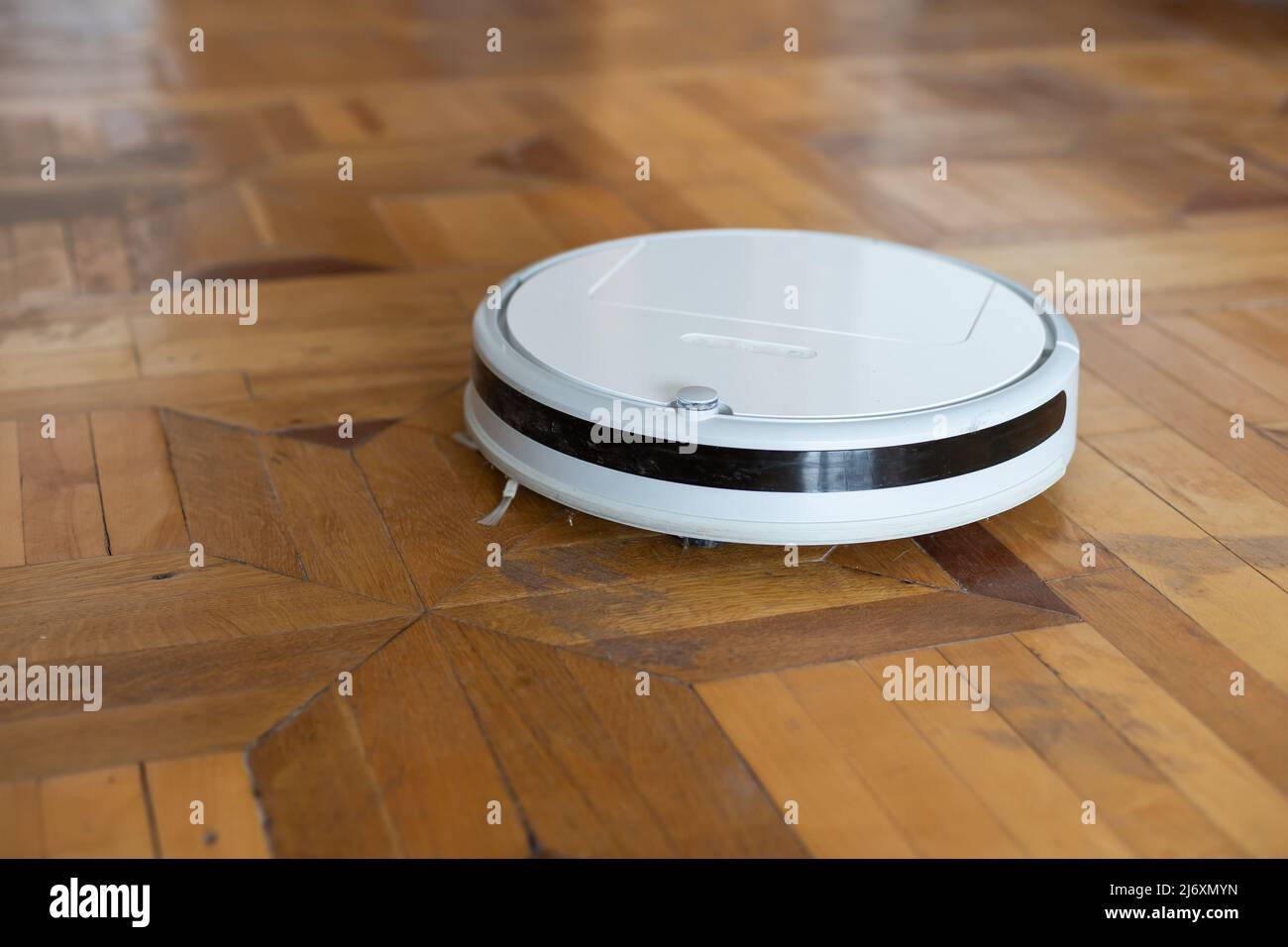 robot vacuum cleaner on the old parquet Stock Photo - Alamy