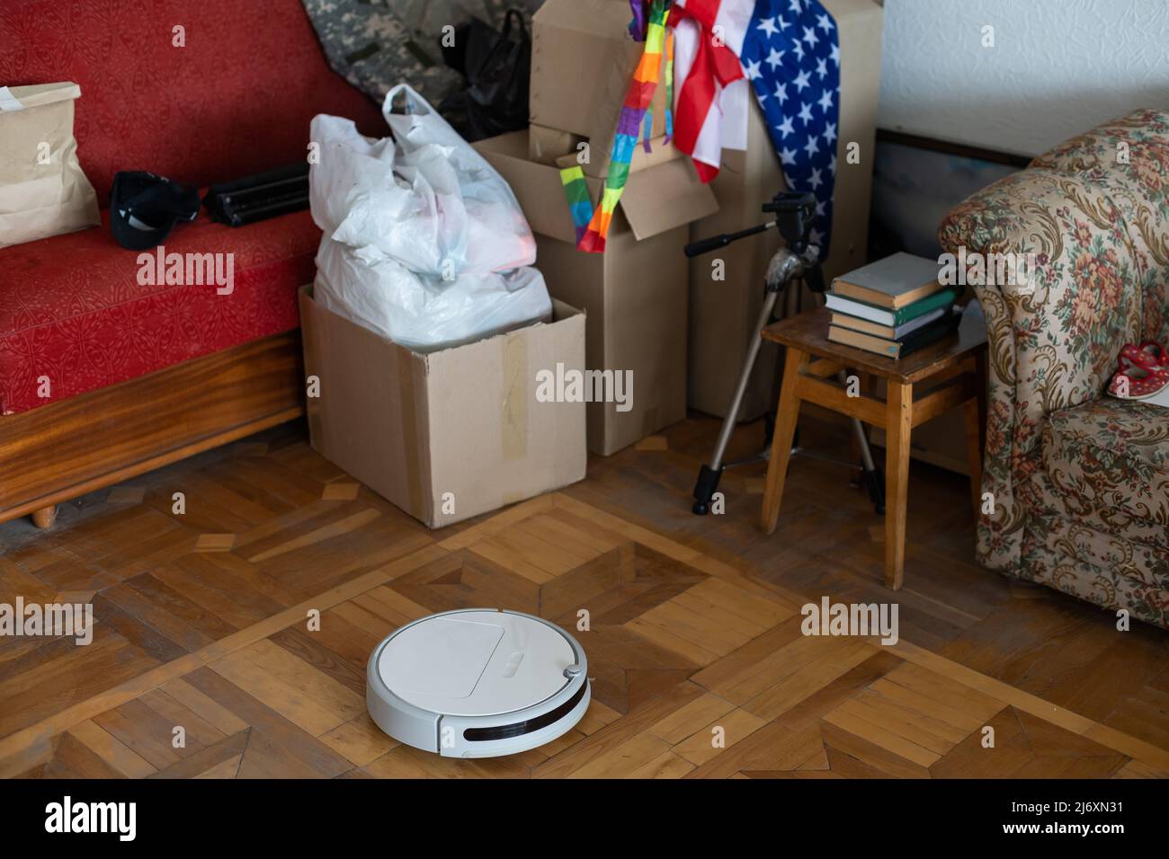 boxes with things to move and robot vacuum cleaner. Stock Photo
