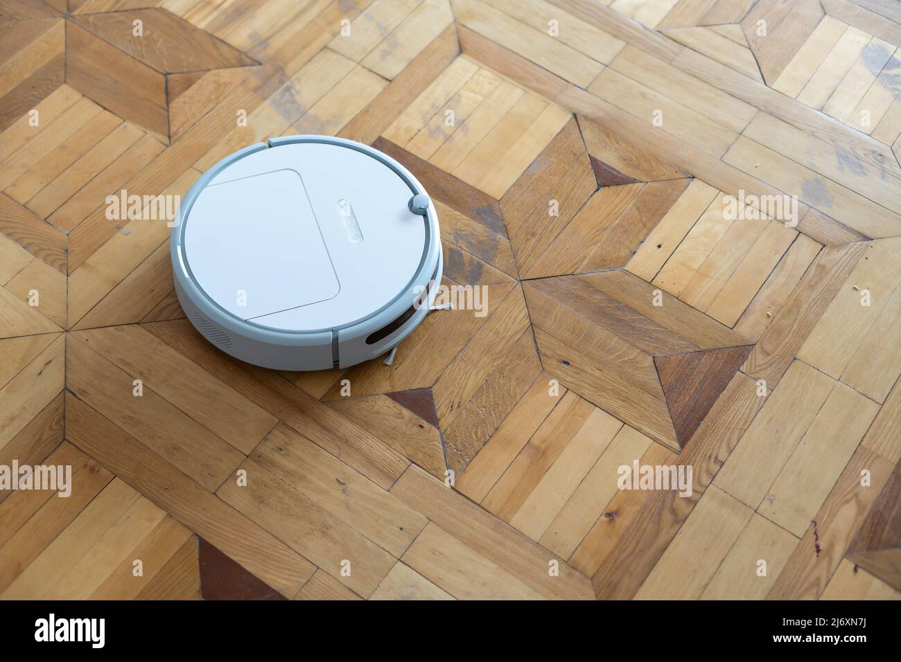 robot vacuum cleaner on the old parquet Stock Photo - Alamy