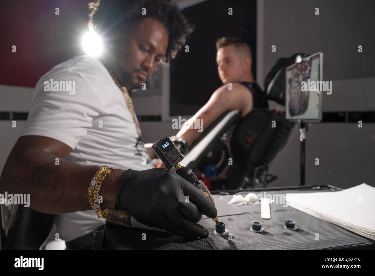 Professional African American tattoo artist makes a tattoo on client